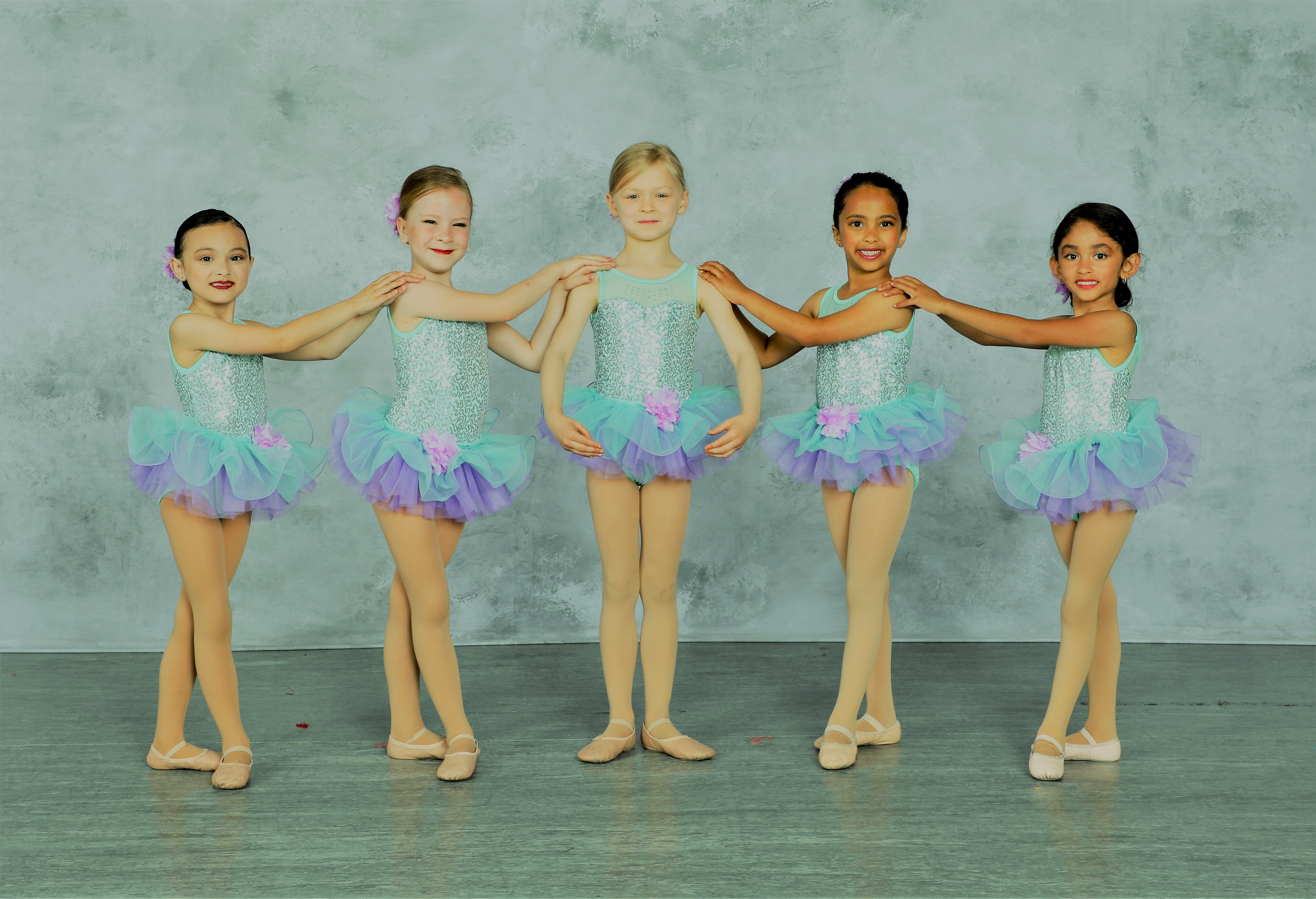 Young dancers in beautiful costumes demonstrating high quality instruction